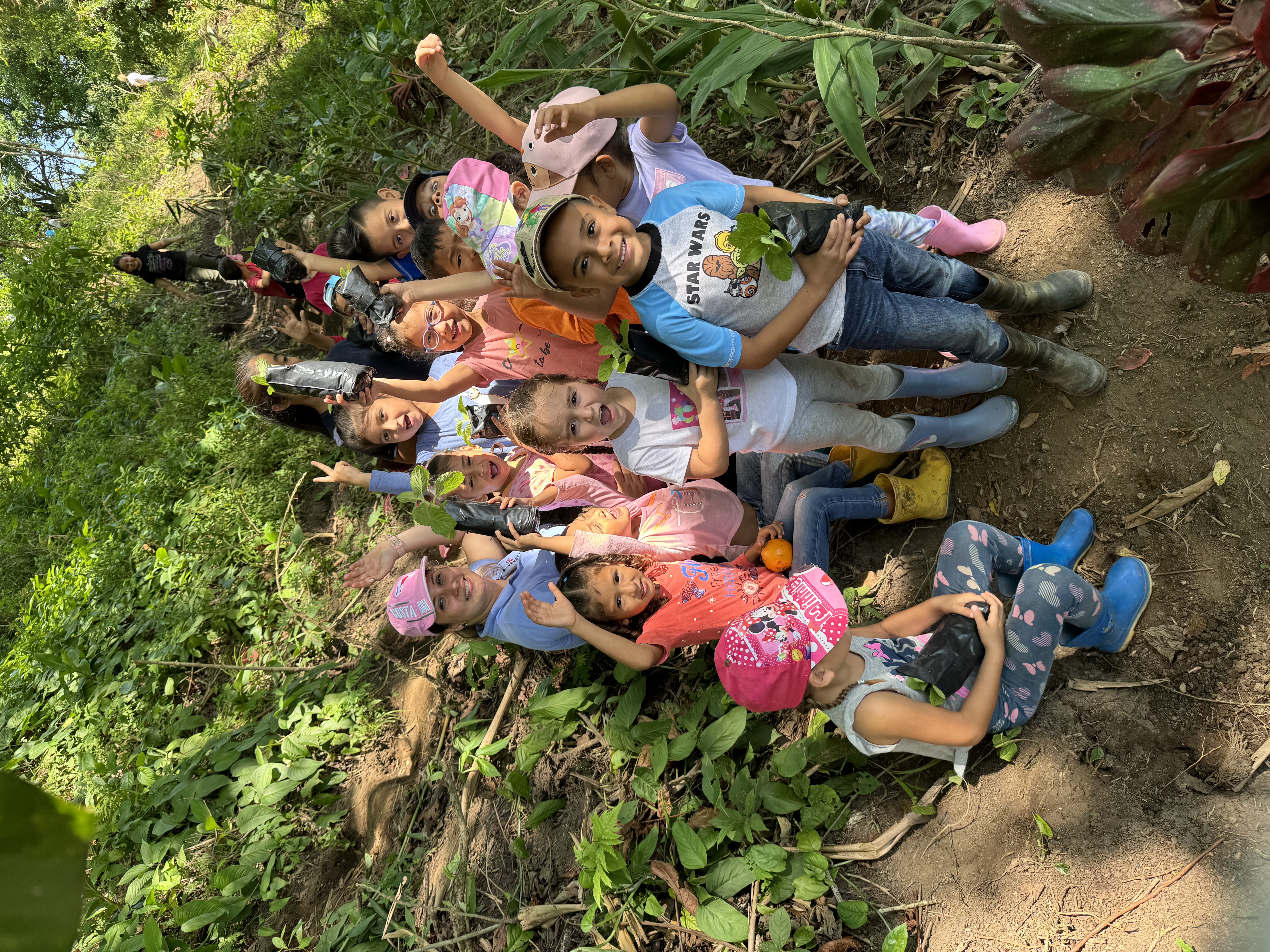 Kinder im Schulwald mit Baumsetzlingen